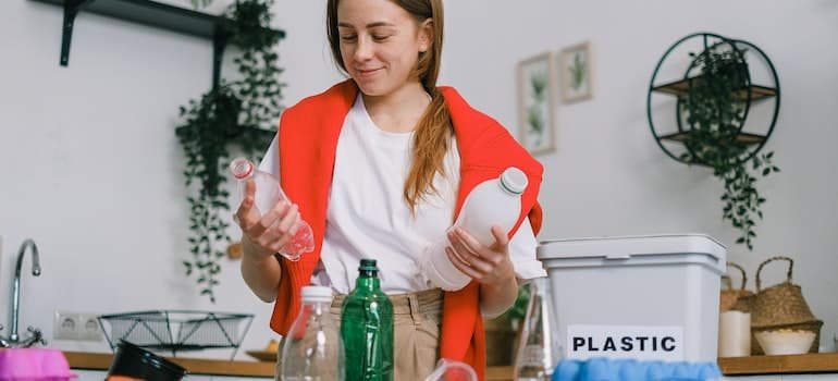 A girl sorting plastic bottles in a room;